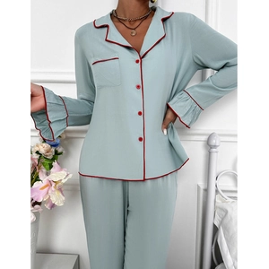 Détail d'un pyjama bleu clair avec passepoil rouge et élégantes manchettes à volants