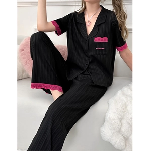 Détail du pyjama noir avec dentelle rose et broderie bonsoir sur la poche de poitrine
