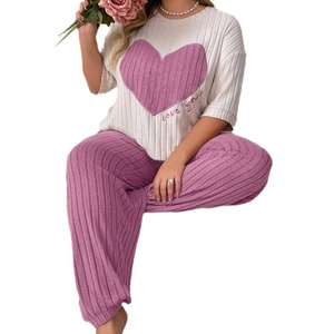 Women's pajama set featuring white heart print top and pink ribbed long pants