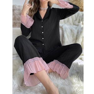 Detail of ruffled cuffs and pink trim on black ribbed long sleeve pajama set