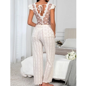 White lace pajama set featuring open back top with bow and floral hollow out pants