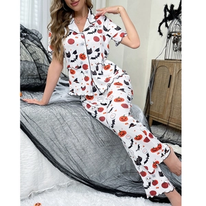 Detail of soft Halloween pajamas featuring vibrant pumpkin, bat, and black cat prints