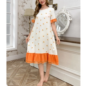 Detail of floral print nightgown featuring orange ruffled hems and textured white fabric