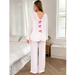 Women's white pajama set with long sleeves, pink ruffle trim and back bow details