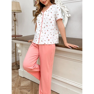 Detail of V-neck cherry print short sleeve top and pink pajama pants on model
