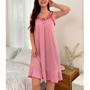 Détail de nuisette rose sans manches avec col à volants et tissu texturé en chambre
