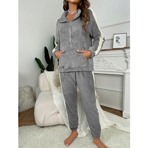 Detail of soft grey fleece pajama set with white side stripes in a cozy home setting