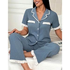 Detail of grey-blue short-sleeved pajama top with white ruffle trim and chest pockets