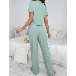 Women's light green V-neck ribbed pajama set with ruffled hem and long pants in bedroom