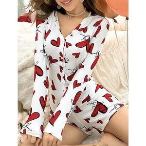 Women V-neck long sleeve pajama jumpsuit with red hearts and script print in cozy bedroom