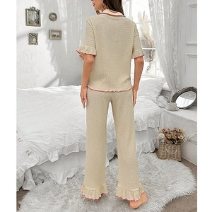 Women's two-piece beige pajama set with pink lettuce edge trim and textured knit fabric