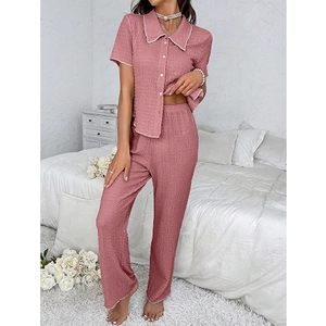 Close-up of pink textured pajama shirt with white piping and front button detail