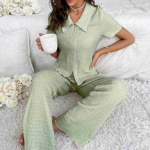 Detail of sage green textured pajama set featuring delicate white lace trim on sleeves