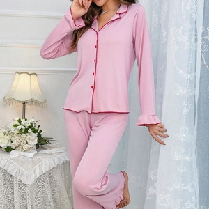 Pink women's long sleeve pajama set with contrasting red trim and ruffled cuffs