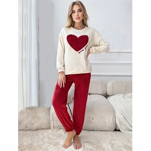 Close-up of soft coral fleece texture on cream heart pajama set with Love you embroidery