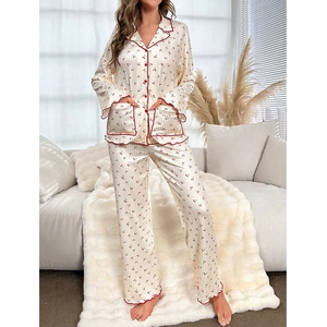 Women's satin cherry print pajama set featuring long sleeves and pants with red ruffles