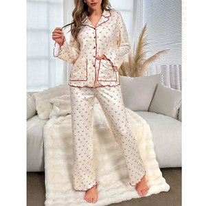 Detail of sweet cherry print pajamas set with luxury satin texture and red piping trim