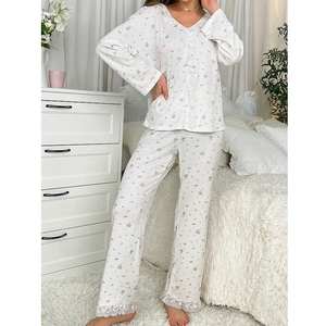 Pyjama floral pour femme avec manches longues et bordure en dentelle dans une chambre cosy