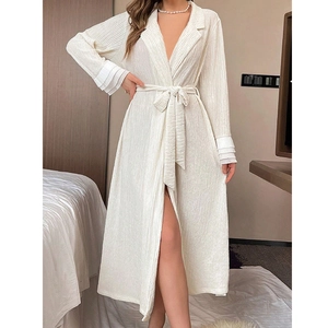 Close-up of pleated cuff details and textured cream fabric on a long sleeve bathrobe
