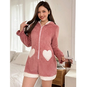 Detail of soft pink plush onesie with white heart-shaped pockets and front zipper closure