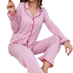 Pink ribbed pajama set with red piping, long sleeve button-down top and ruffled pants