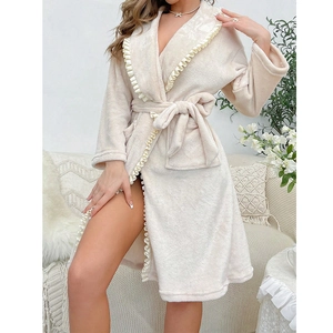 Detailed close-up of cream fleece bathrobe with ruffled edges and lace-up waist tie