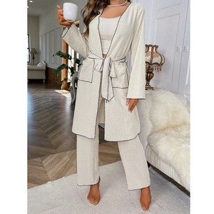 Detailed view of cream-white three-piece pajama set with contrast black stitching and texture