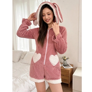 Close-up of pink fleece onesie showing cute rabbit ears hood and white heart shaped pockets