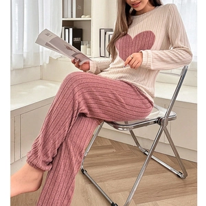 Detail of ribbed knit loungewear set featuring pink heart patch on long sleeve cream top