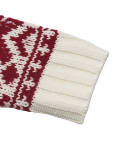 Close-up of red and white knit sweater cuff featuring festive snowflake jacquard pattern
