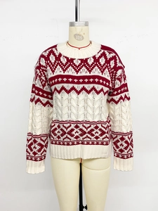 Detail of red and white Fair Isle knit sweater with cable stitch and geometric patterns