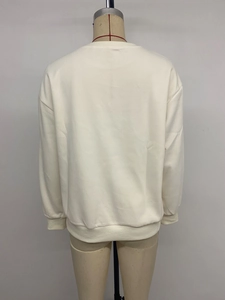 Detail view of the ribbed hem and cuffs on the cream minimalist long sleeve sweatshirt