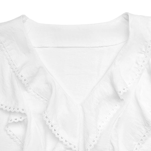 Close-up of white blouse with deep V-neck featuring ruffled edges and lace details