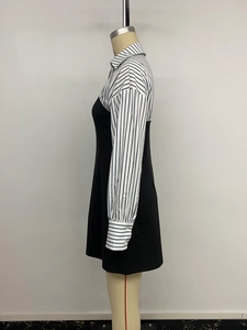 Detail of blue striped shirt sleeves and black vest dress layered patchwork design