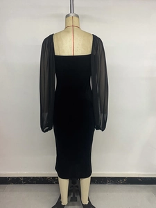 Detail view of square neckline and sheer mesh puff sleeves on a black velvet midi dress