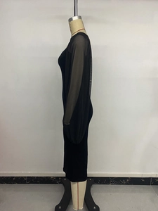Detail of sheer mesh puff sleeves and fitted velvet texture on a black midi dress