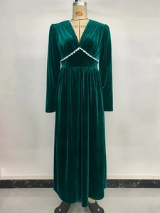 Detail of dark green velvet maxi dress showing V-neck and white lace waist trim