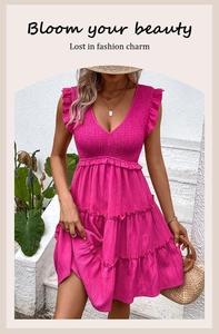 Détail du buste smocké et de la jupe à volants étagés sur une robe d'été rose sans manches