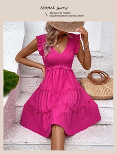Détail de la robe d'été fuchsia avec buste froncé et texture de jupe à volants étagés