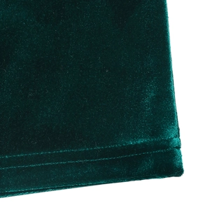 Macro shot of dark green velvet fabric texture and fine stitching detail on dress edge
