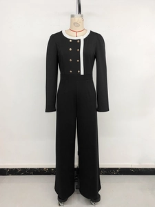 Detail of the white contrast collar and double-breasted gold buttons on the jumpsuit