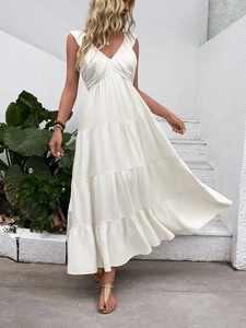 Detailed view of tiered skirt layers and premium pleated fabric on white maxi dress