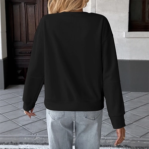 Women's minimalist black long sleeve sweatshirt with ribbed cuffs and blue jeans