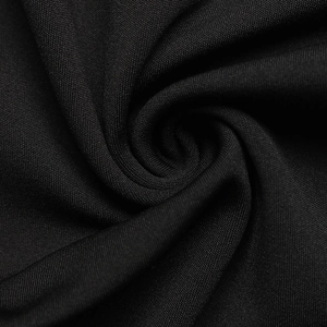 Macro view of pure black fabric texture showing elegant folds and soft material quality
