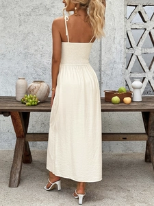 Detail of smocked elastic back and spaghetti straps on a chic beige summer midi dress