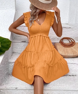 Détail du buste smocké et des volants étagés de la robe orange d'été