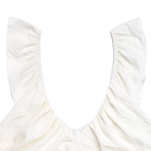 Dettaglio di un abito estivo bianco con spalle a volant, scollo a V e cerniera invisibile