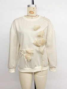 Close-up of 3D organza tulip floral applique on cream long-sleeve crewneck sweatshirt