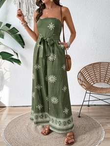 Detail of bohemian strapless jumpsuit with ethnic prints and tied waist and wide legs