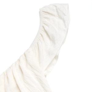 Dettaglio dell'elegante scollatura a pieghe su un abito estivo bianco in tessuto morbido